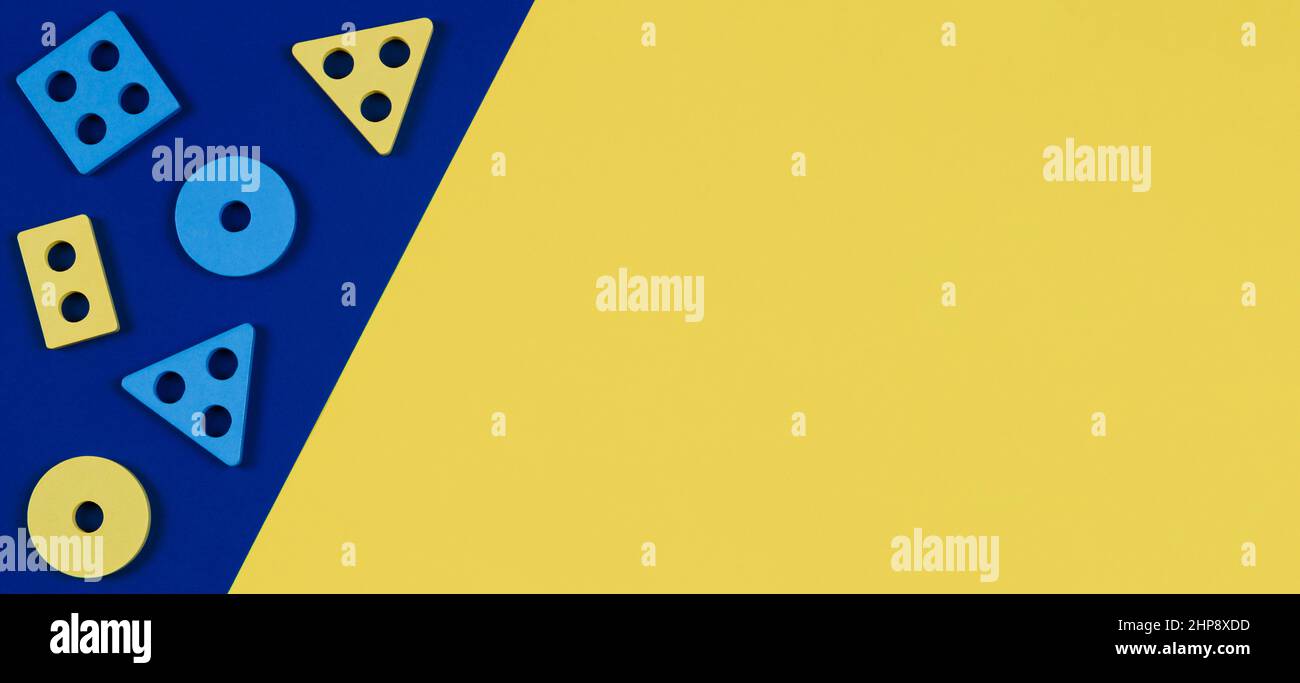 Vue de dessus sur les blocs de bois de la forme trieur pièces jouet sur fond jaune et bleu de couleur. Jouets éducatifs en bois Montessori pour enfants. Petite enfance Banque D'Images