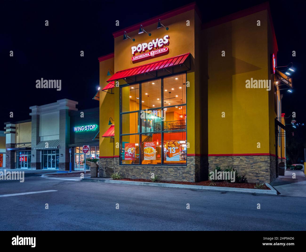 Kissimmee, Floride - 4 février 2022 : vue de nuit horizontale de l'extérieur du bâtiment du restaurant Popeyes. Banque D'Images