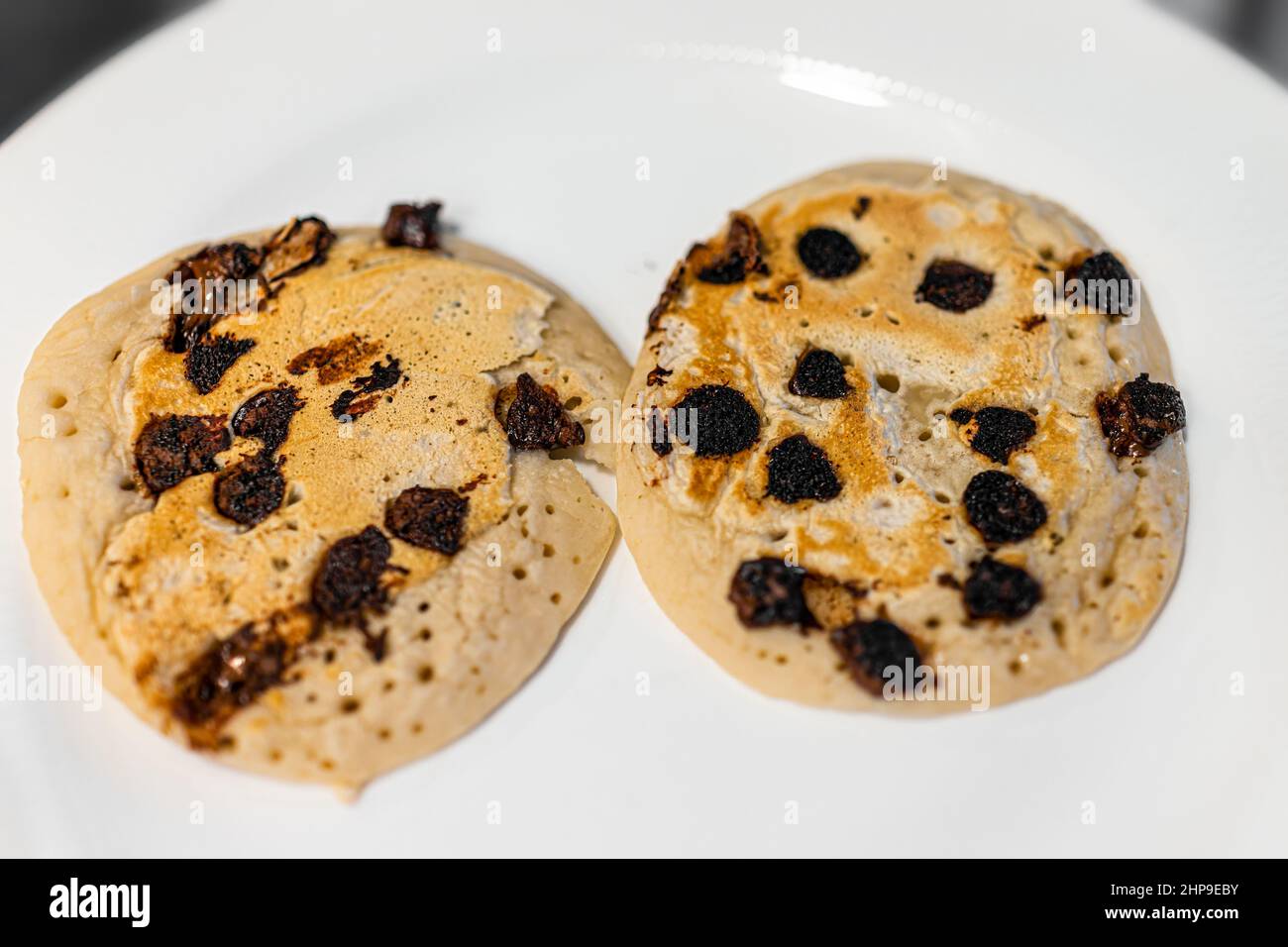 Macro gros plan au-dessus de la vue de deux crêpes aux pépites de chocolat noir au babeurre sur l'assiette comme dessert traditionnel pour le brunch du petit déjeuner Banque D'Images