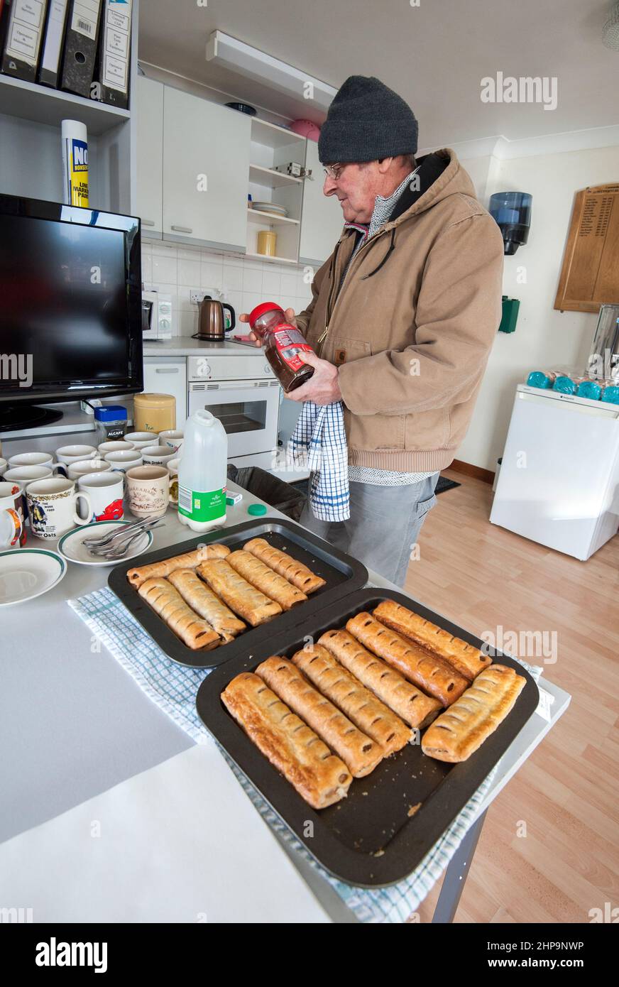 homme solitaire réchauffé la nourriture à l'événement de club Banque D'Images