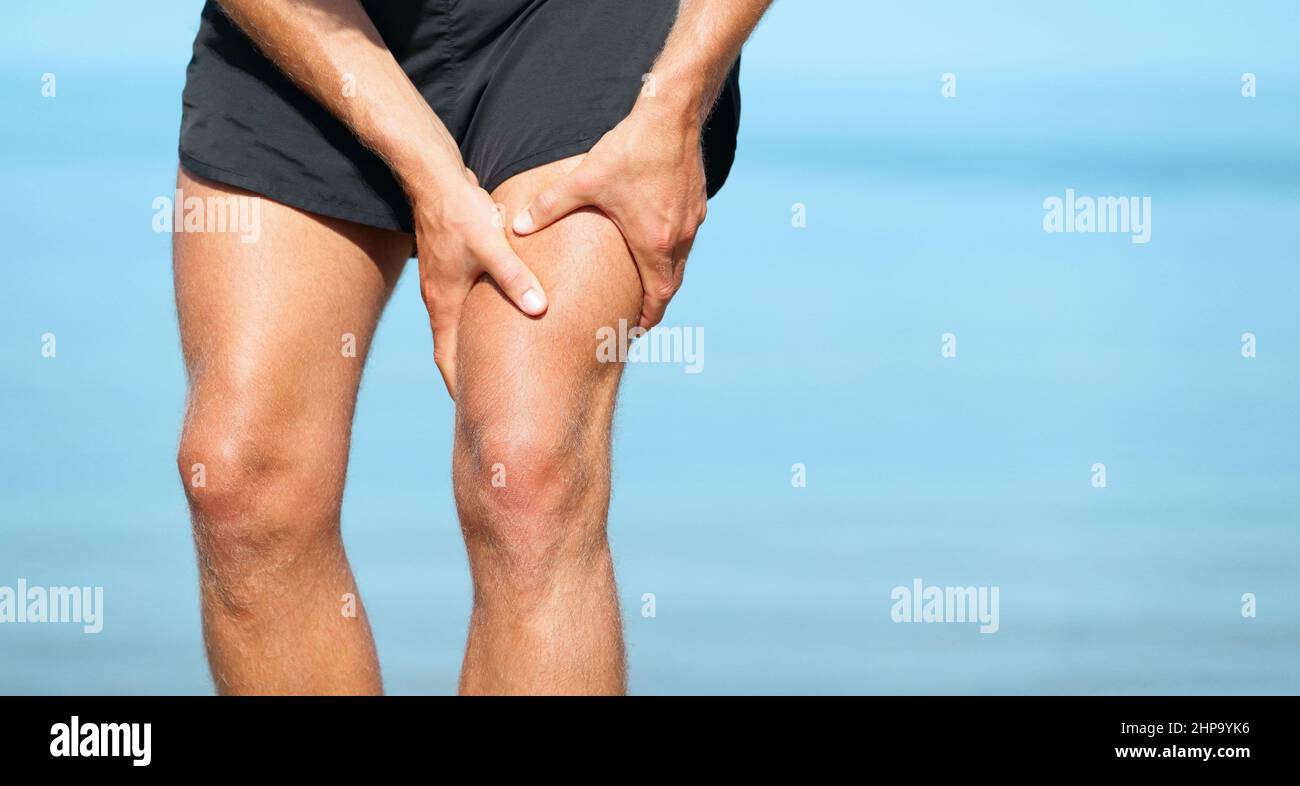 Sports blessure muscle crampes douleur ajustement coureur homme athlète tenant la jambe douloureuse de cuisse sur l'exercice de jogging extérieur d'été. Style de vie physique Banque D'Images