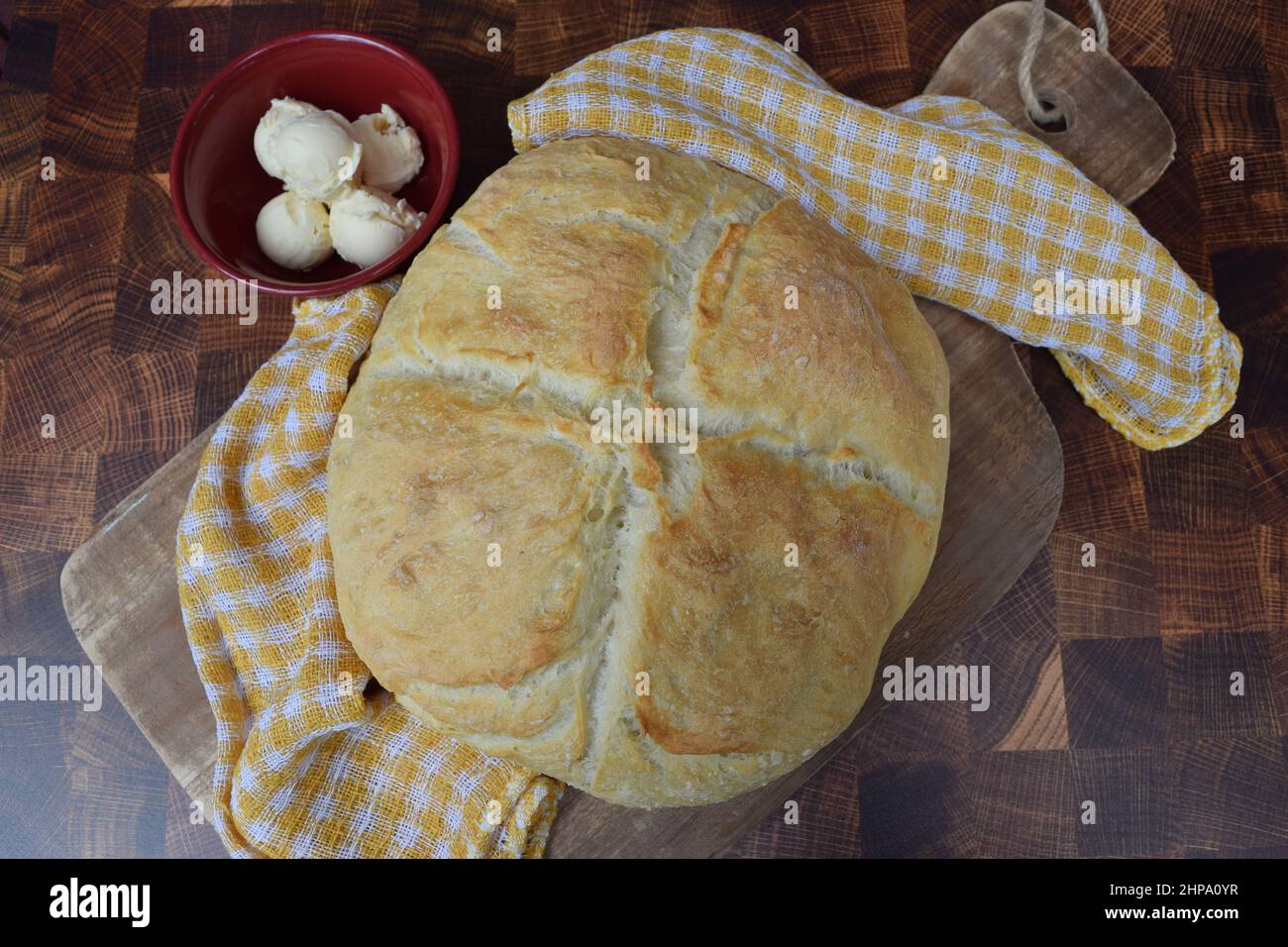 Pain rustique fait maison au four hollandais avec des chiffons, boules de beurre sur bois. Banque D'Images