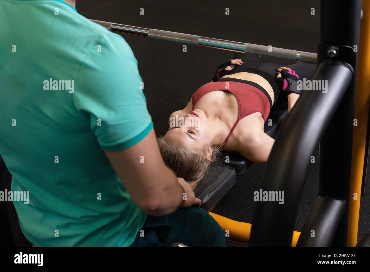 L'entraînement dirigé par un instructeur aide un beau client à effectuer des exercices dans un club de remise en forme, le concept de jouer du sport avec un loisir professionnel de gym Banque D'Images