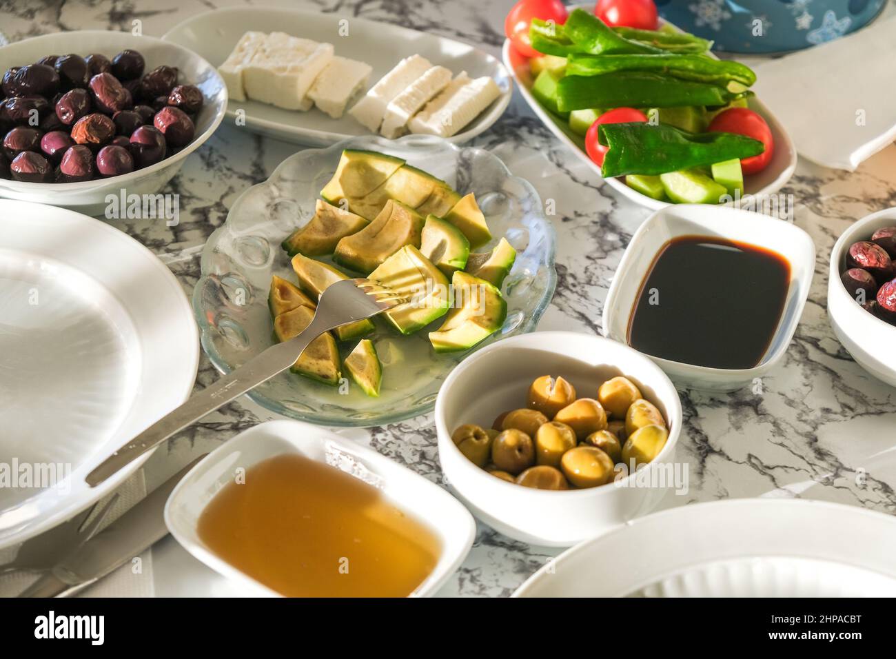 Sélection de petit déjeuner traditionnel turc, fromage, miel, olive, mélasse de raisin, et légumes servis au soleil du matin. Banque D'Images