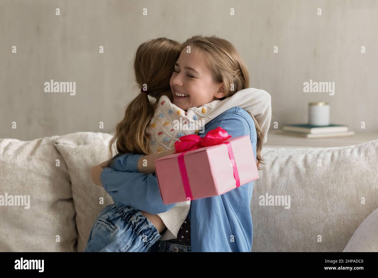 Maman reconnaissante excitée embrassant petite fille d'âge préscolaire avec amour Banque D'Images