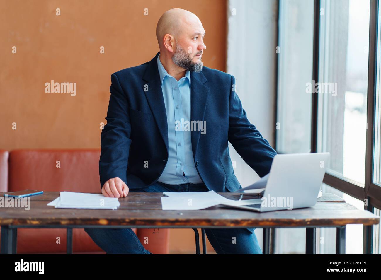 Homme d'affaires chauve, adulte fatigué, barbe, travail occupé, ordinateur portable de bureau en bois, affaire Banque D'Images