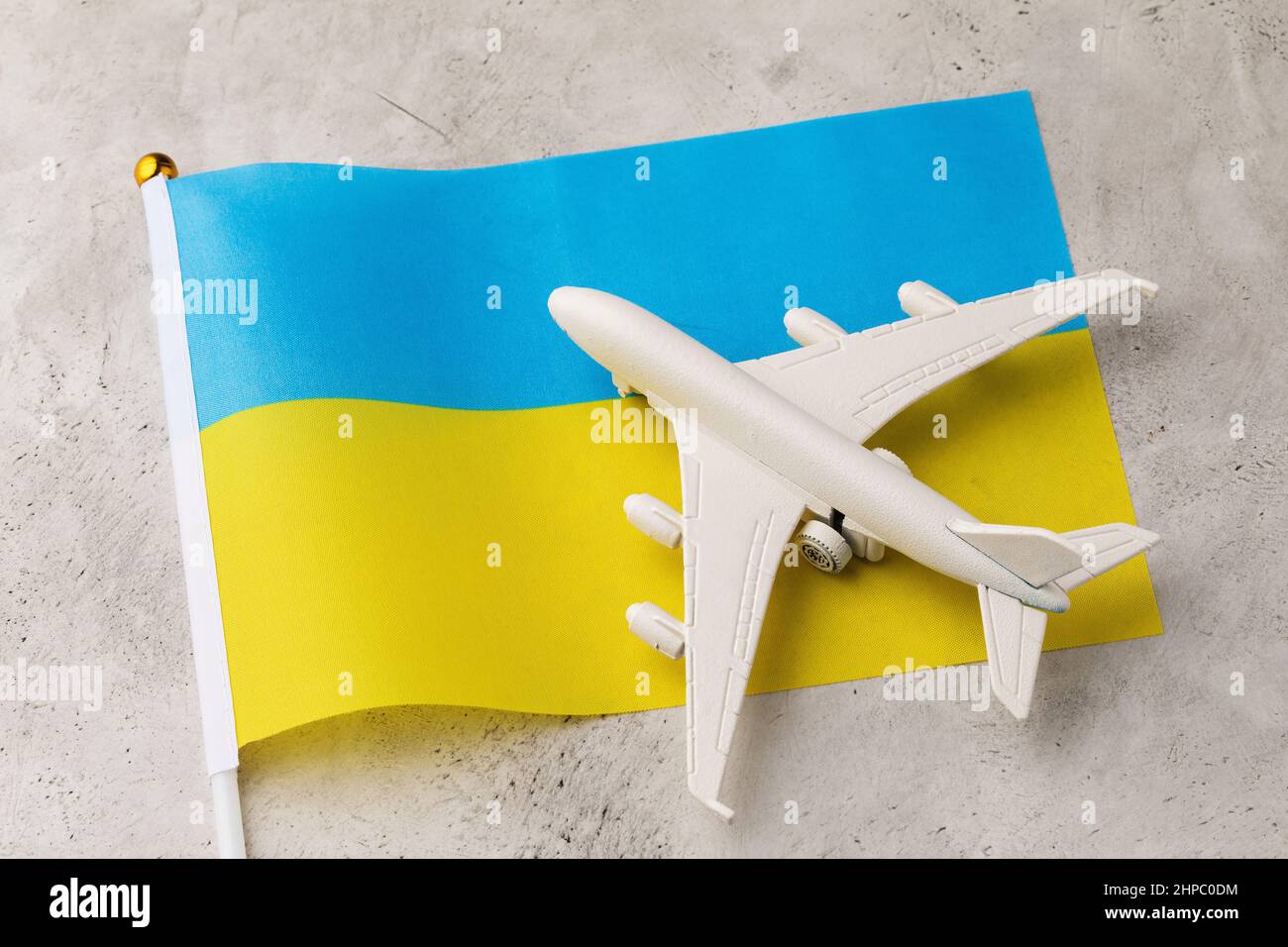 Drapeau ukrainien et avion jouet sur un fond abstrait, un concept sur le thème du voyage en Ukraine Banque D'Images