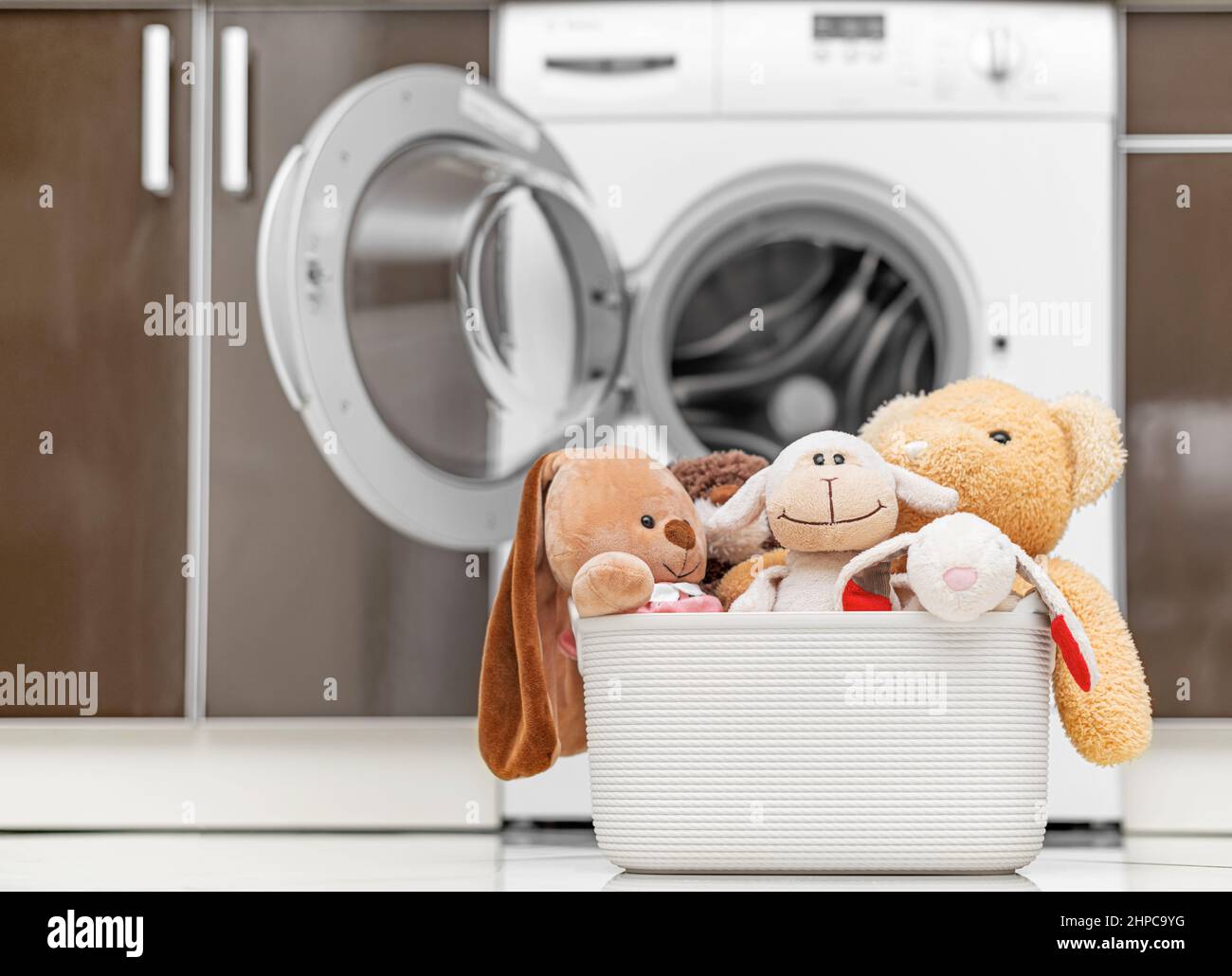 Jouets pour enfants dans un panier à l'arrière-plan d'une machine à laver  Photo Stock - Alamy