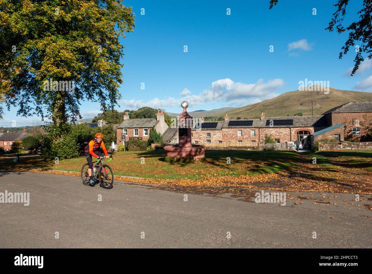 Vue de Dufton avec Great Dun est tombé en arrière-plan et un cycliste, Eden Valley, Cumbria, Angleterre, Royaume-Uni Banque D'Images