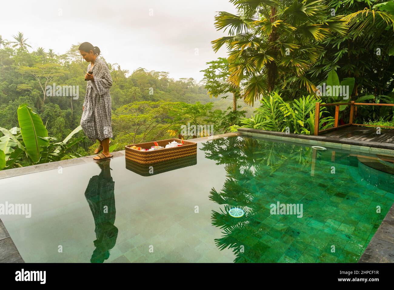 Femme prenant le petit déjeuner flottant dans un complexe de luxe à Bali Banque D'Images