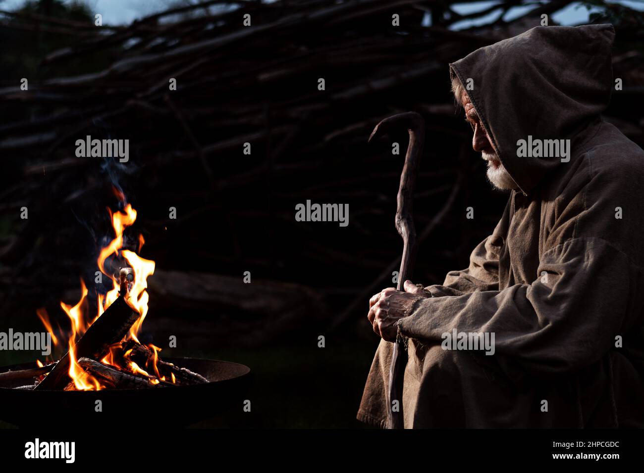 Vieux moine au Moyen Age autour du feu de camp Banque D'Images