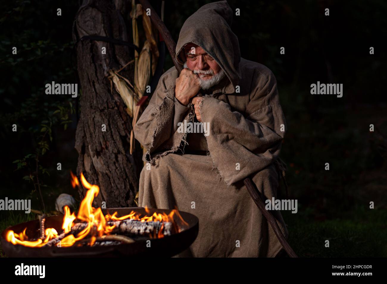 Vieil homme au Moyen âge autour du feu de camp Banque D'Images