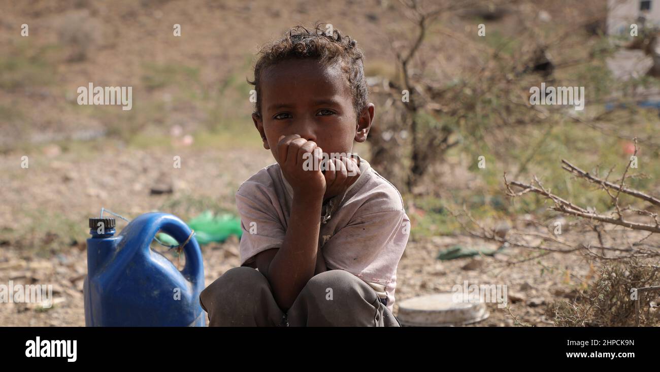 Taiz Yémen - 18 février 2022 : Un enfant triste recherche de l'eau dans les camps pour les personnes déplacées de la guerre dans la ville de Taiz, Yémen Banque D'Images