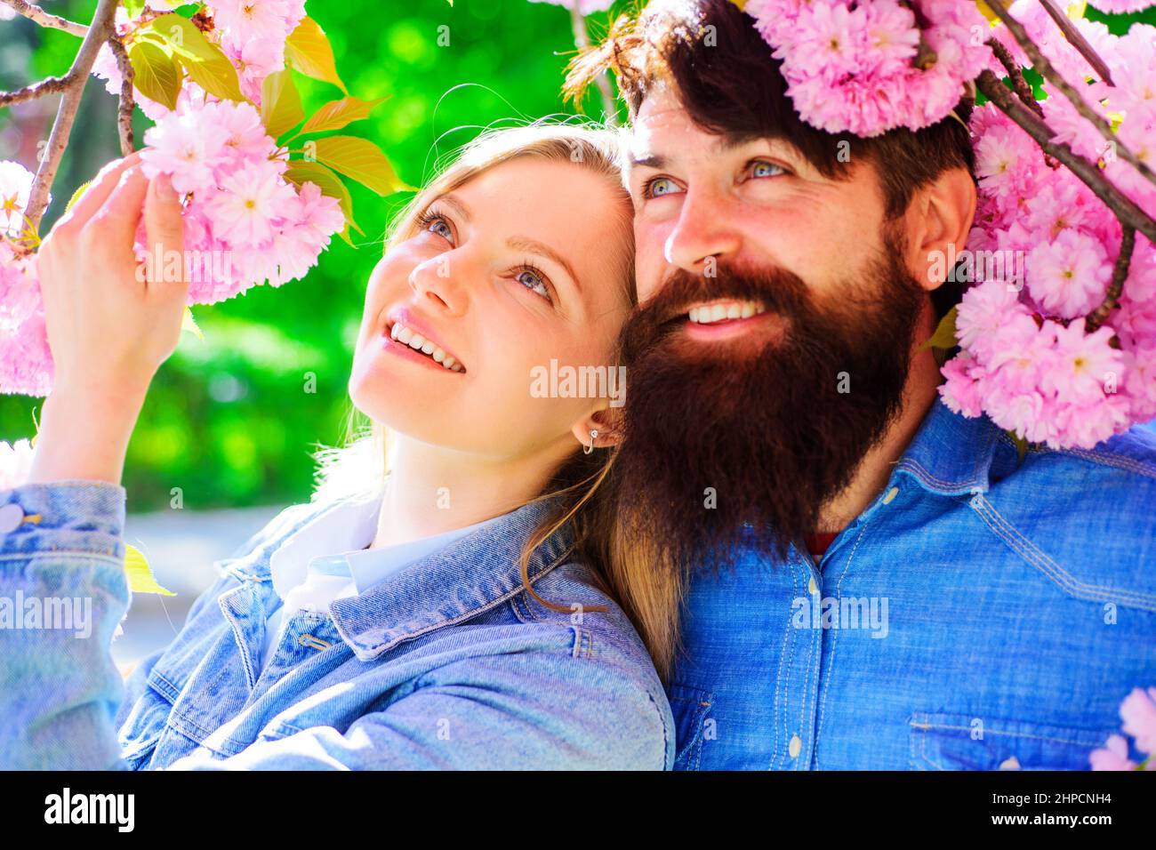 Printemps. Fleur de sakura printanière. Couple heureux dans le jardin de printemps. Promenade familiale touristique dans le parc. Banque D'Images