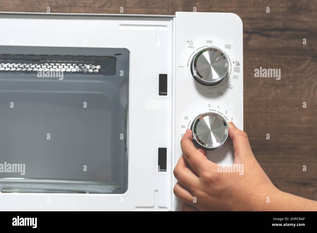 main à l'aide d'un four. Fille Réglage de la température du four à  micro-ondes. Utilisation du four à micro-ondes. Régulateur de puissance,  contrôle de la température Photo Stock - Alamy