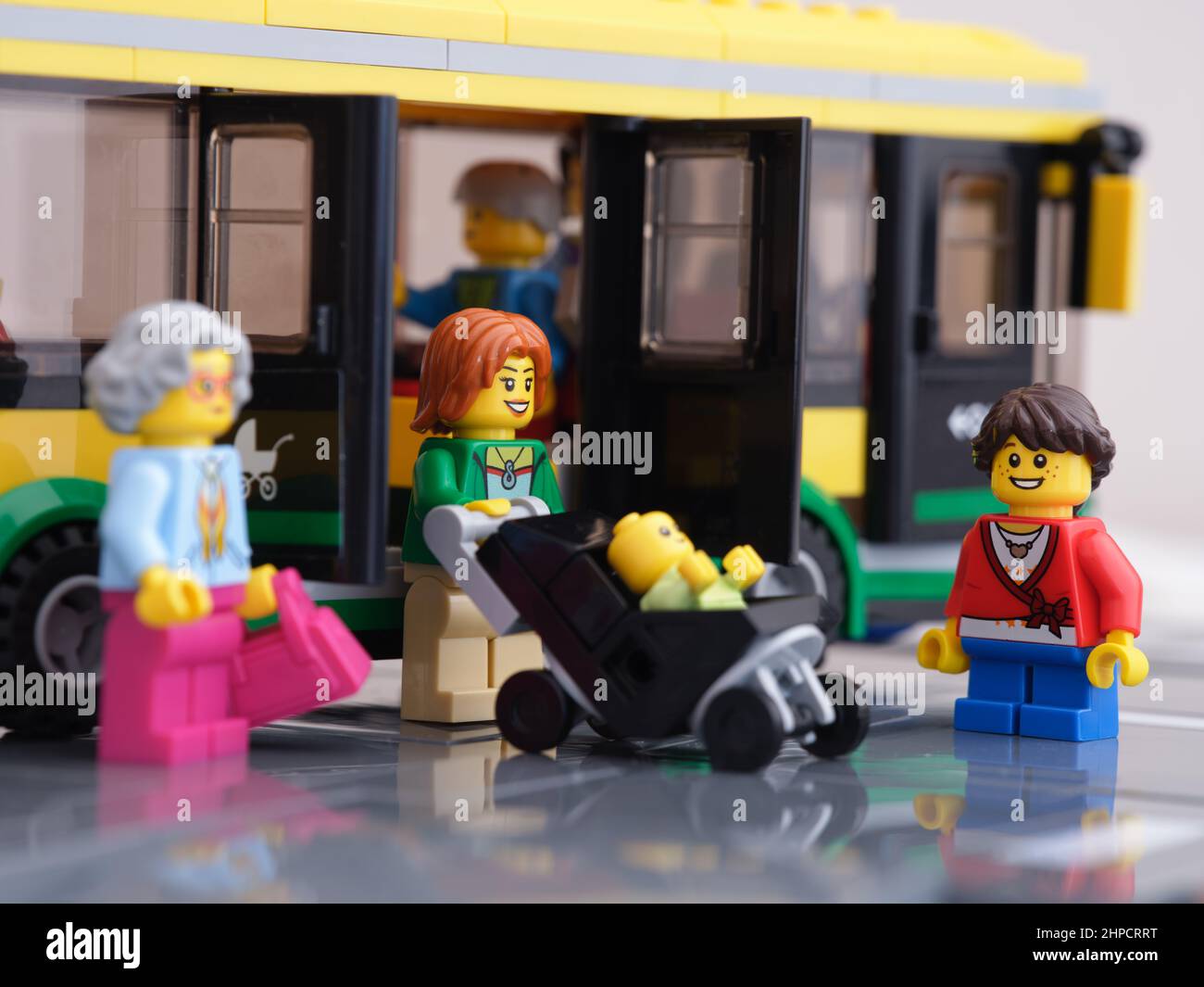 Tambov, Fédération de Russie - 16 février 2022 Une femme de Lego mini-figuration sortant d'un bus avec une poussette avec un enfant en elle tandis que d'autres minifigu de Lego Banque D'Images