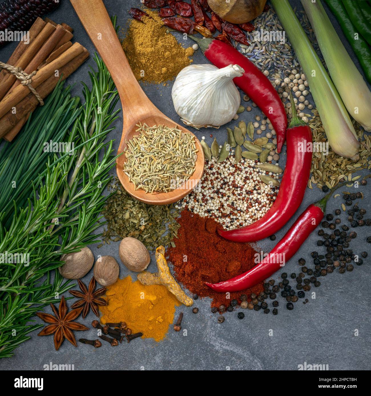 Herbes et épices sur fond gris ardoise avec espace pour le texte. Les herbes et les épices sont utilisées pour ajouter de la saveur et de l'assaisonnement à la nourriture pendant la cuisson. Banque D'Images