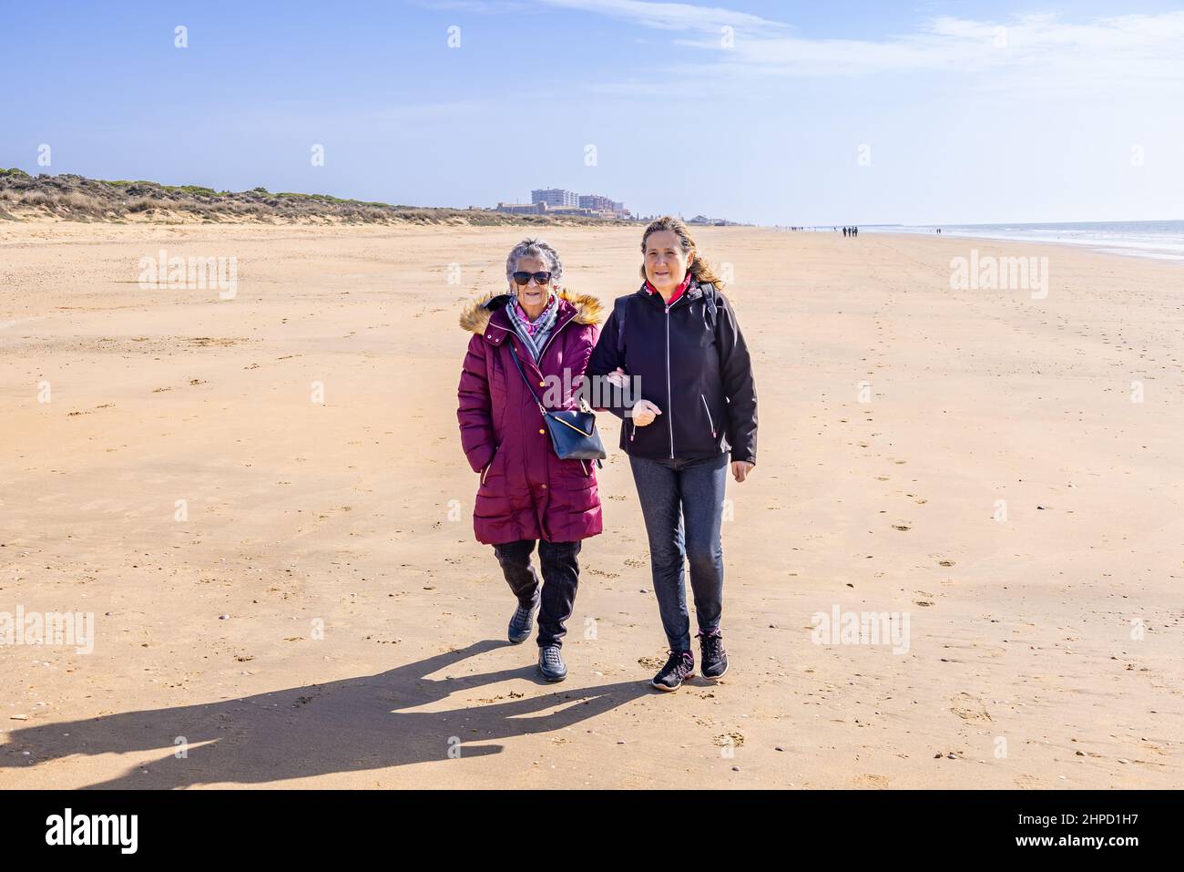Une femme mûre marchant avec sa mère âgée près de la plage à l'automne Banque D'Images