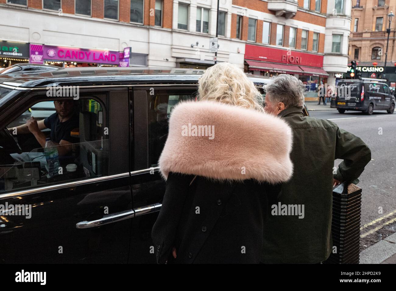 Un couple âgé hante un taxi londonien sur Charing Cross Road, Londres, Royaume-Uni Banque D'Images