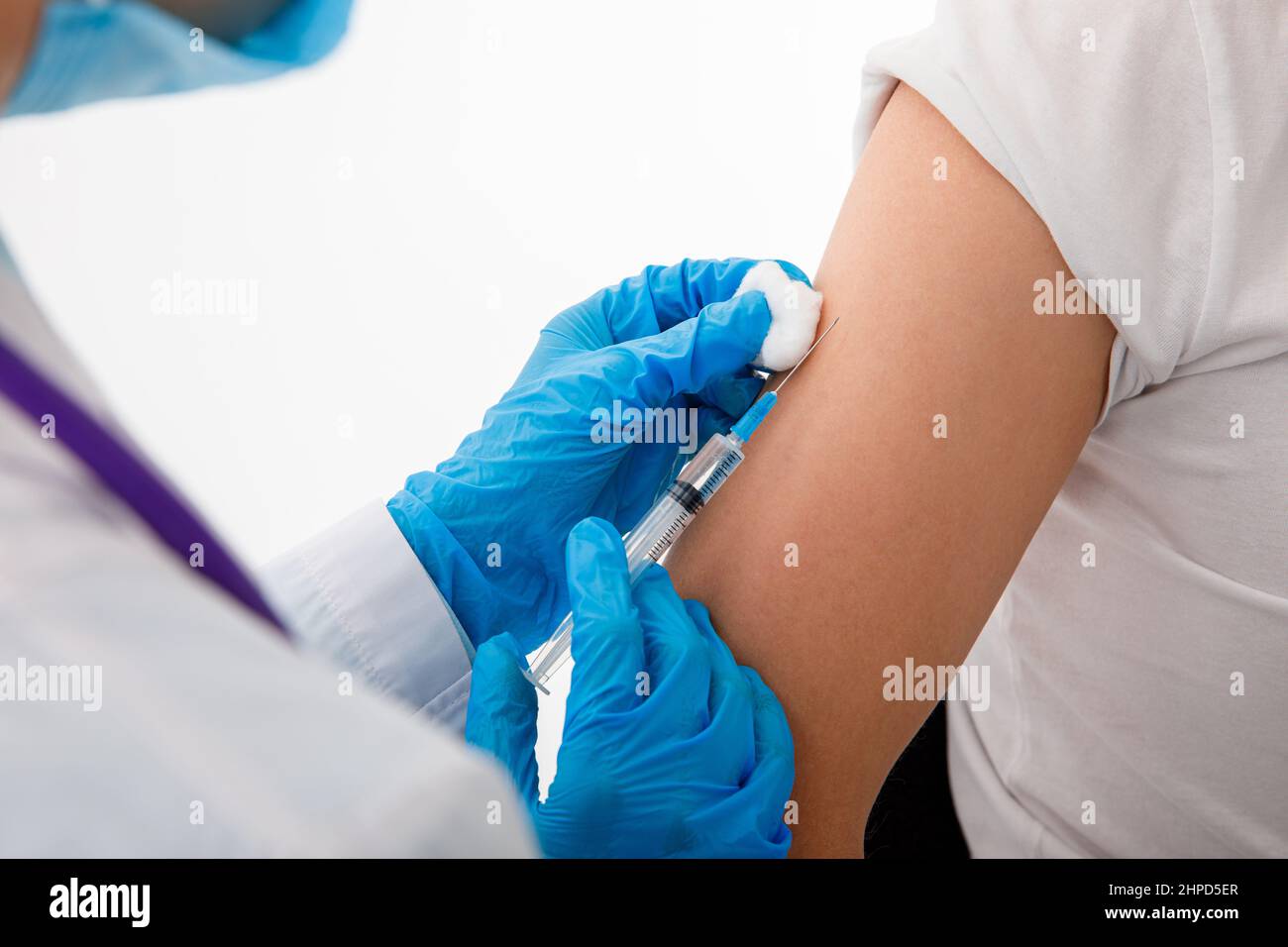 Le médecin tient une seringue avant de donner une injection à un patient dans un masque médical. Vaccin Covid-19 ou coronavirus. Banque D'Images