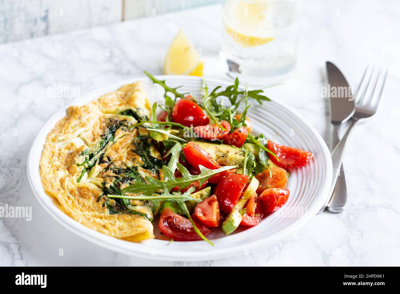omelette avec salade d'arugula et de tomates Banque D'Images