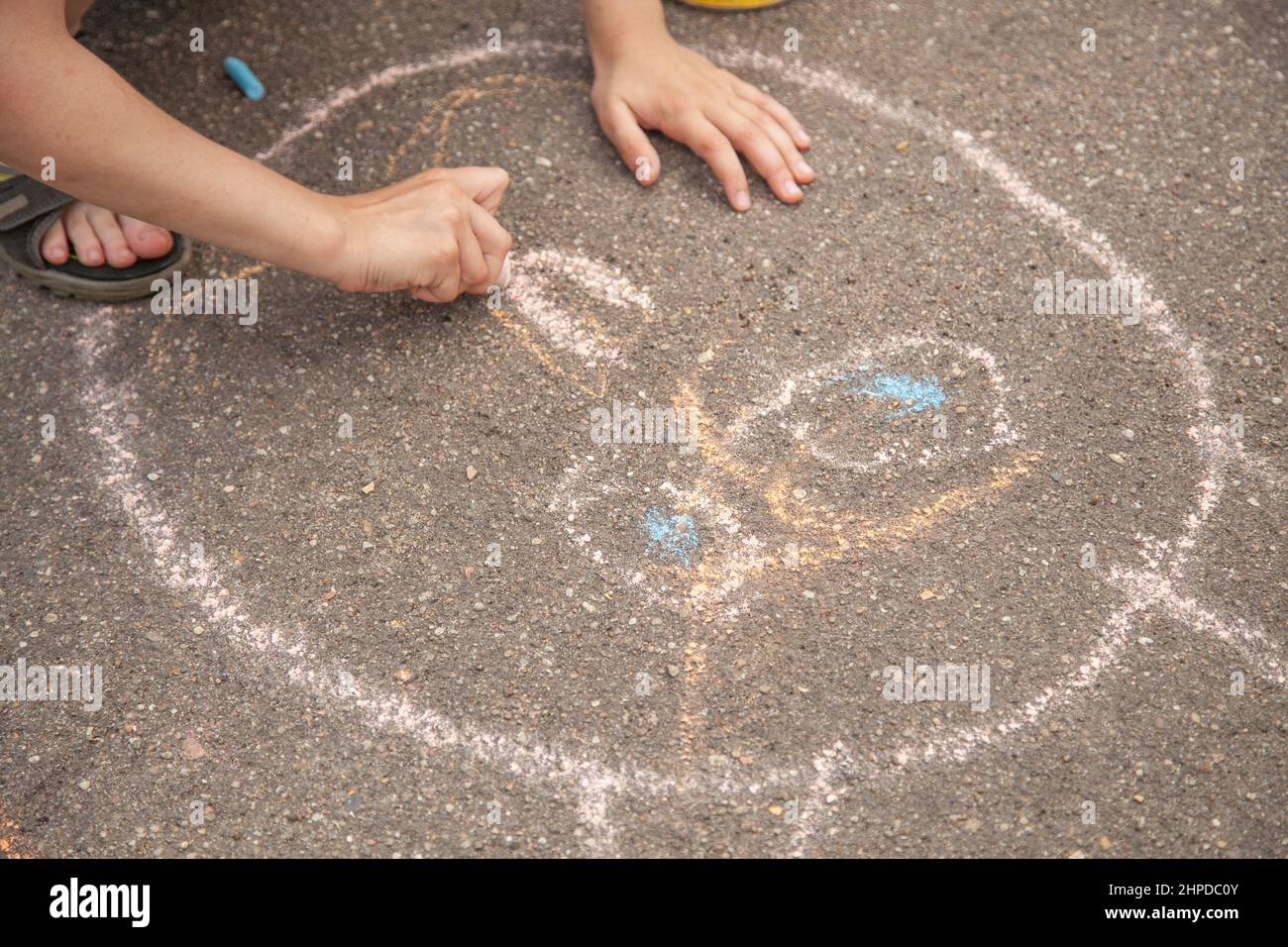 Les enfants dessinent avec de la craie sur le trottoir. L'enfant crée une image. Les beaux-arts pour les enfants. Vacances avec les enfants en été en ville. Un rapide Banque D'Images