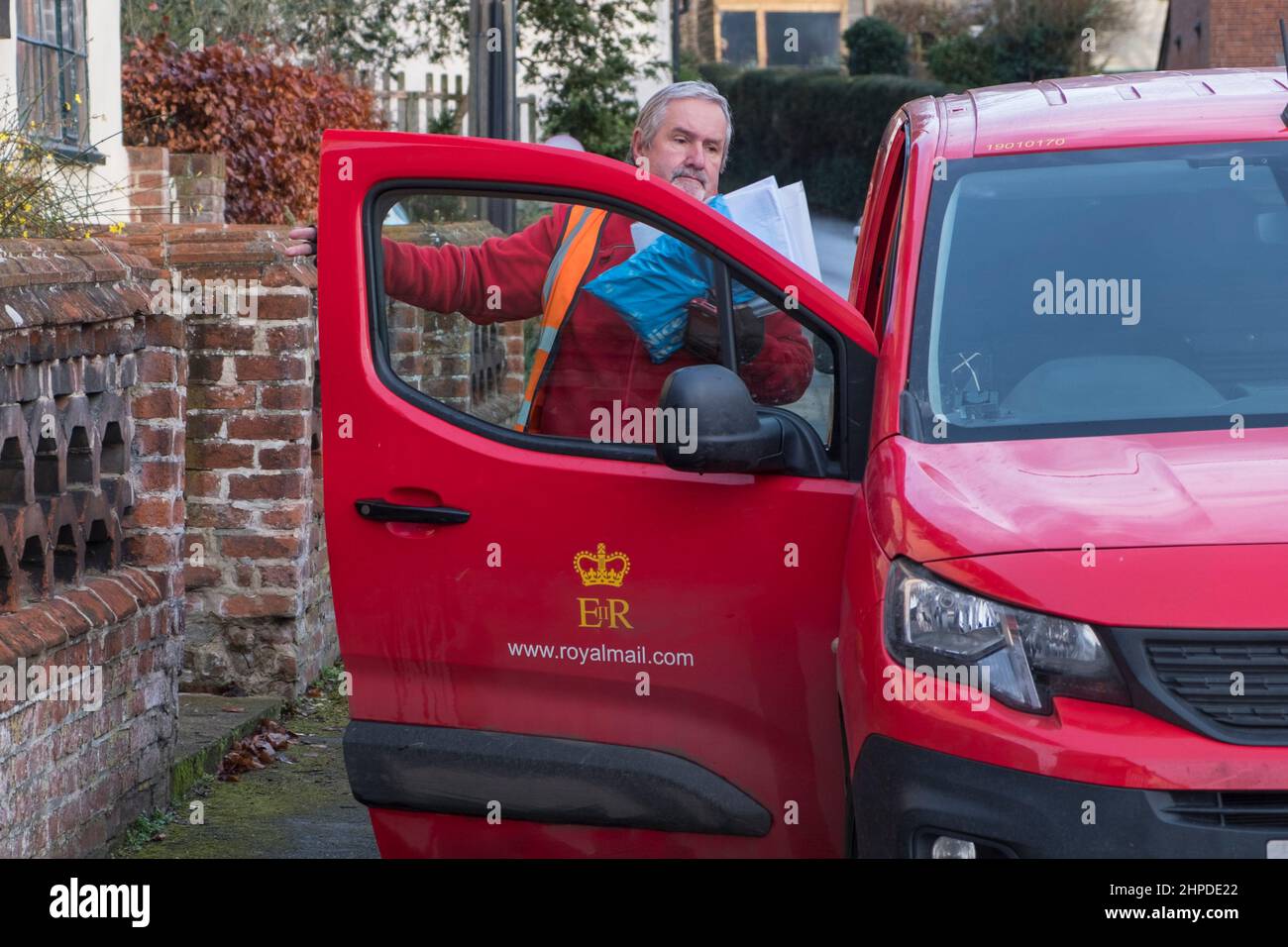Facteur et van livrant des lettres dans un village du Suffolk, Royaume-Uni. Banque D'Images