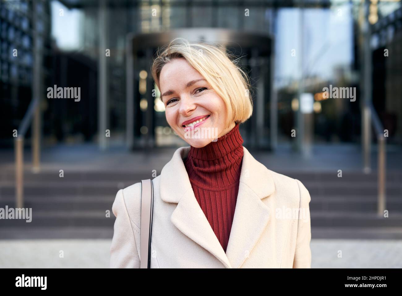 Femme blanche blonde d'âge moyen à la recherche heureuse de l'appareil photo. Belle femme mûre souriante. Banque D'Images