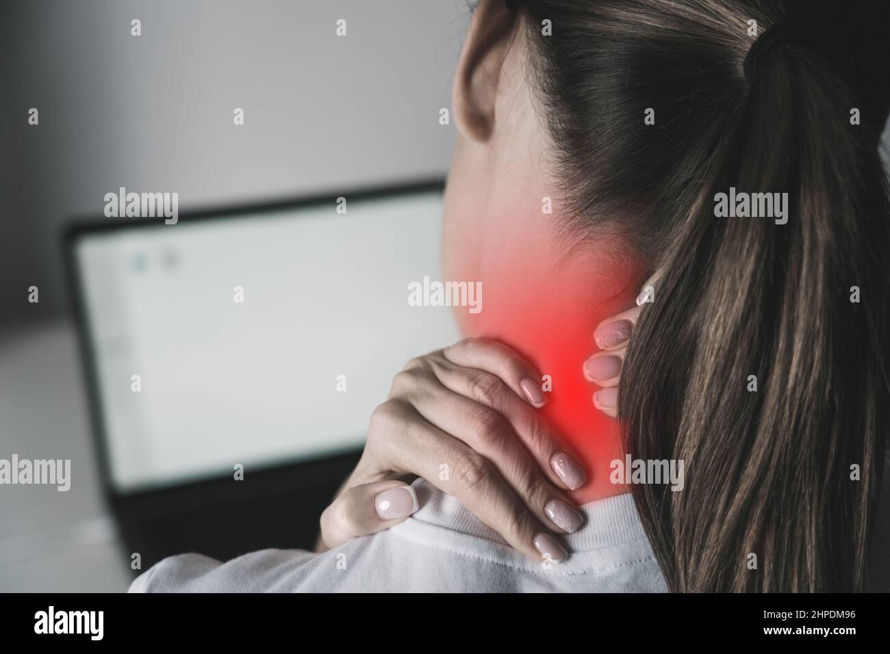 Femme souffrant de douleurs au cou après avoir travaillé sur un ordinateur portable Banque D'Images