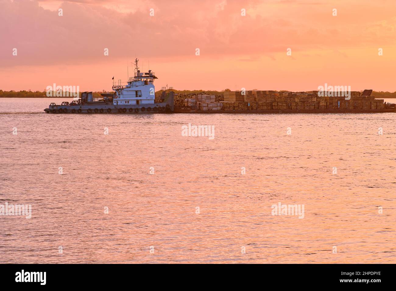 Khabarovsk, Russie - 29 septembre 2021 : coucher de soleil sur le remblai de l'Amur à Khabarovsk. Une barge avec du bois flotte sur la rivière. Le niveau du Banque D'Images