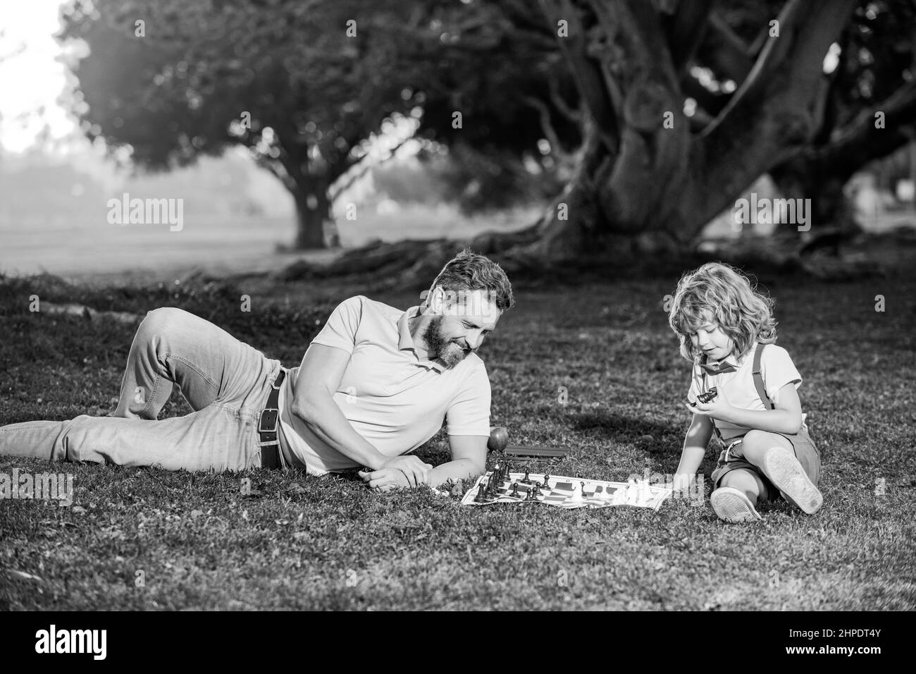 Une famille heureuse à l'extérieur. Père et fils jouant aux échecs. Banque D'Images