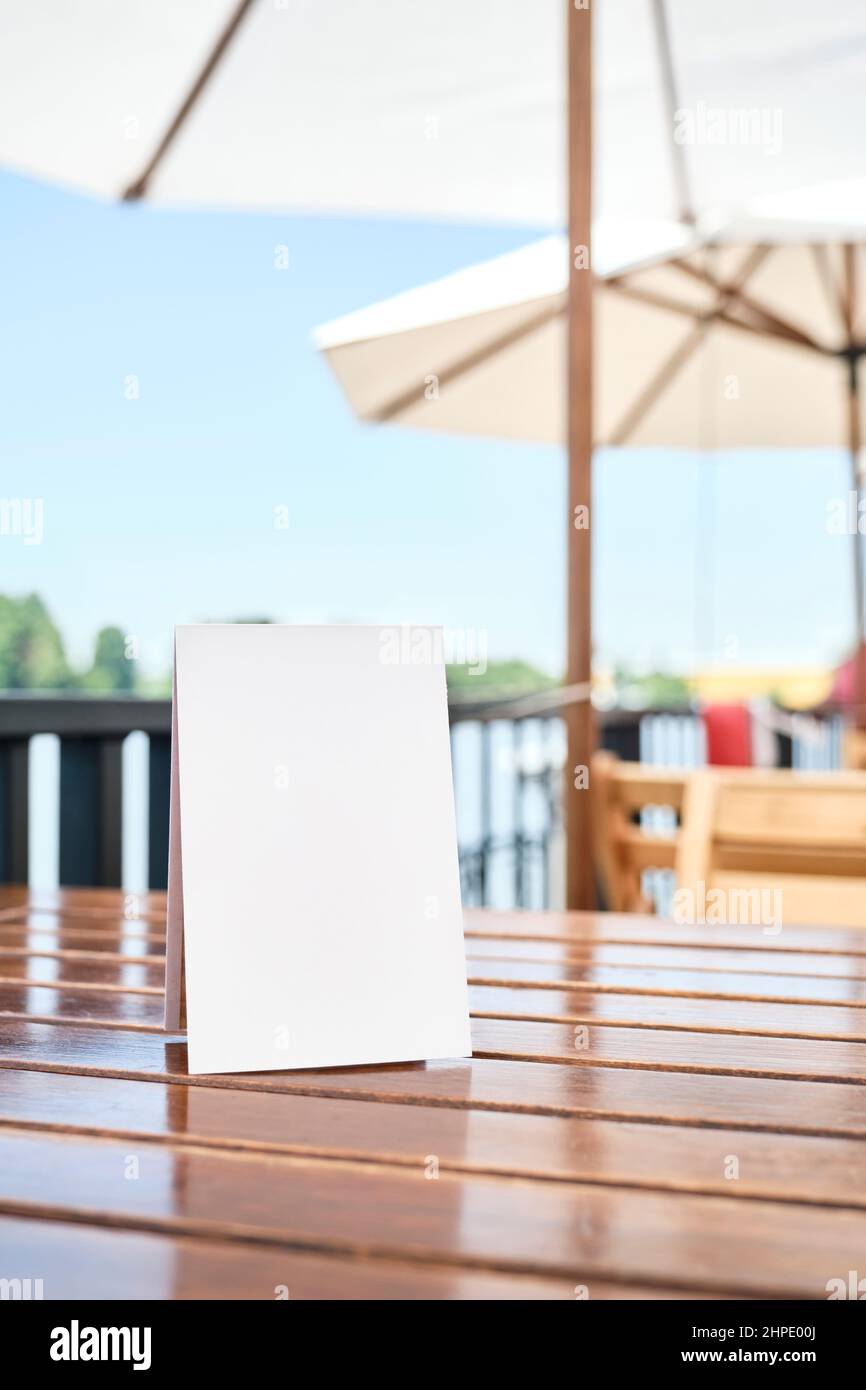 Affiche vierge sur une table sur la terrasse d'un restaurant, à l'extérieur, en été. Espace blanc pour afficher un texte, un menu, des produits, des promotions ou d'autres informations Banque D'Images