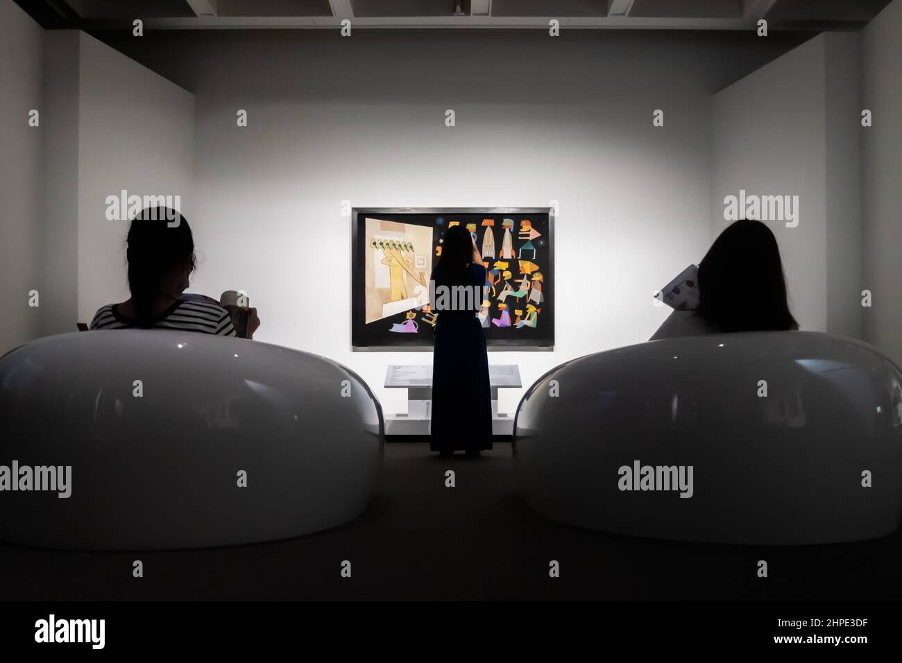 Silhouette de personnes regardant un morceau d'œuvre dans la galerie d'art Banque D'Images
