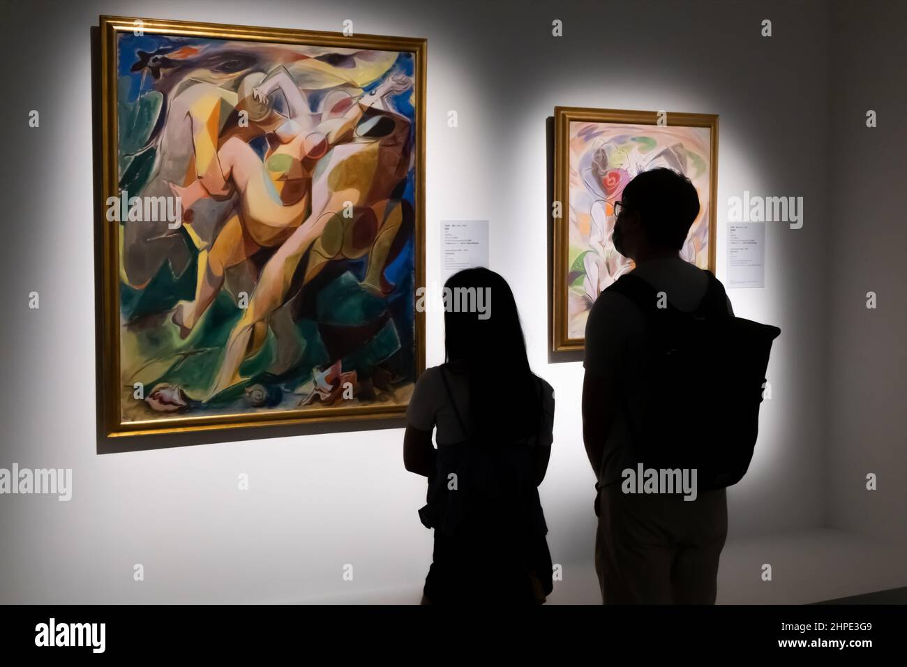 Silhouette d'homme et de femme regardant un morceau de peinture dans une galerie d'art Banque D'Images
