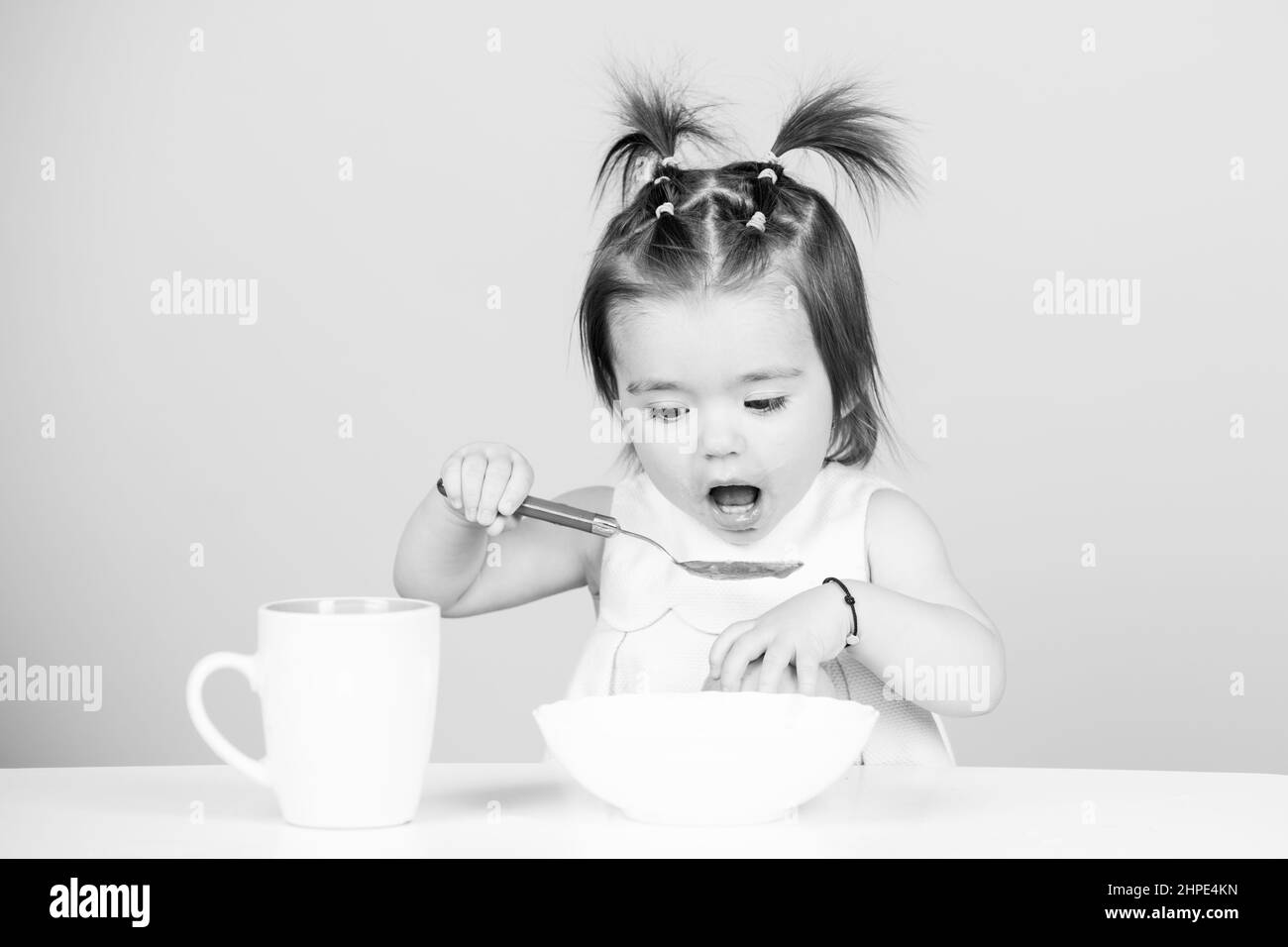 Mignon bébé enfant manger de la nourriture, les bébés manger.Petit bébé mangeant de la purée de fruits. Banque D'Images