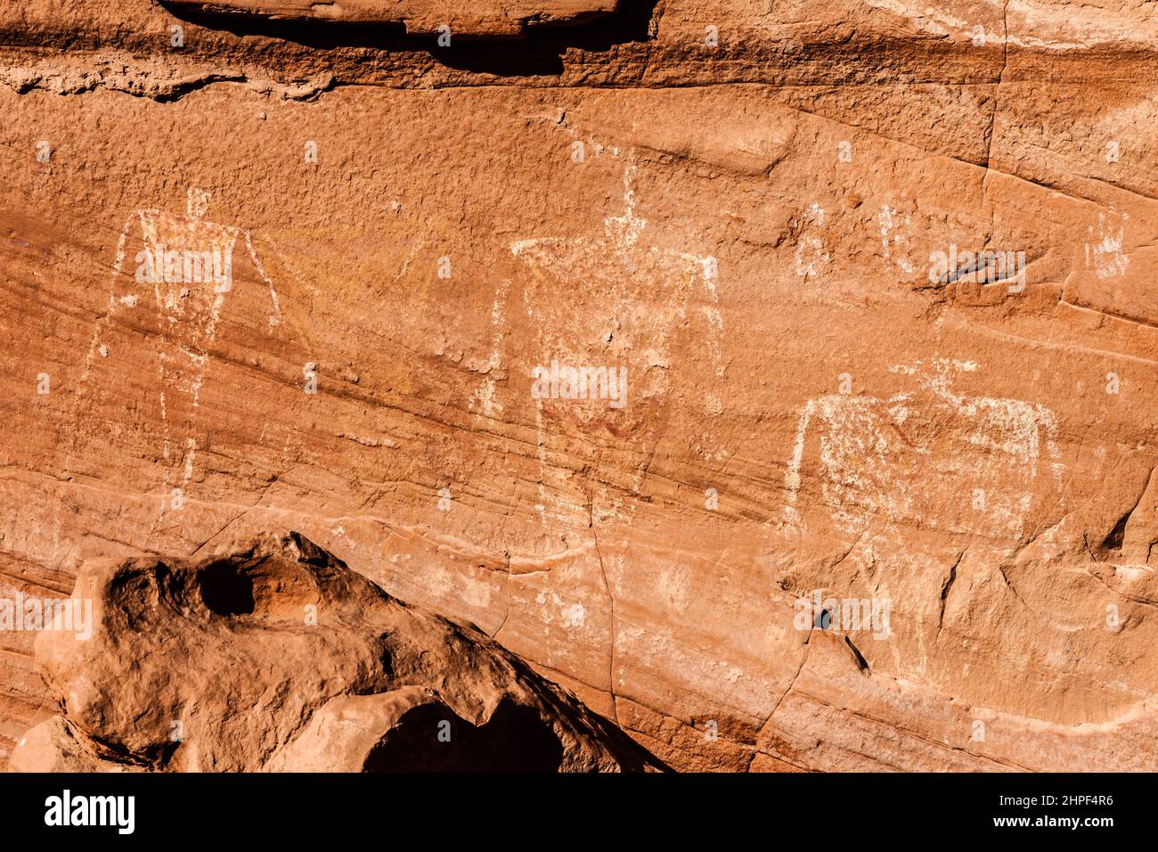 Le mur de grès au-dessus des nombreuses mains ruinantes dans la vallée du mystère dans le parc tribal de Navajo Monument Valley est couvert d'art rupestre vieux de 1000 ans de t Banque D'Images