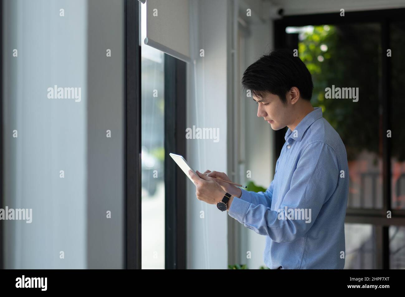 Homme d'affaires asiatique utilisant une tablette numérique pour l'analyse marketing en salle de réunion. Banque D'Images