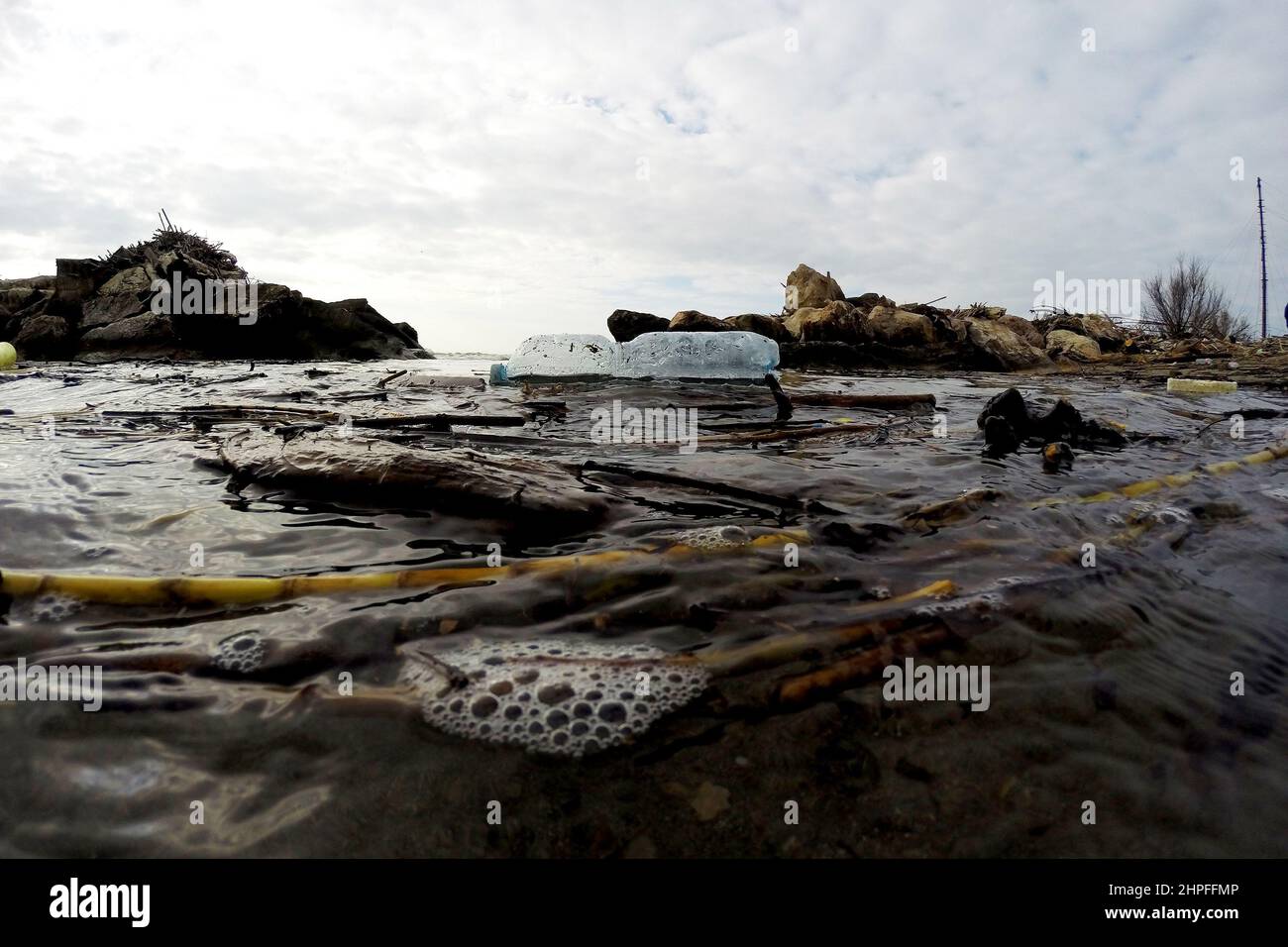 Castel Volturo, Italie, 20 février 2022. Une bouteille en plastique et d'autres déchets flottent sur l'eau, lors d'un nettoyage effectué par les volontaires de l'Association Plasticfree sur la 'Plage en plastique' de Castel Volturno, ainsi appelé pour l'énorme quantité de déchets accumulés par le déluge de la rivière Volturno. Castel Volturo, Italie, 20 février 2022. Crédit: Vincenzo Izzo/Alamy Live News Banque D'Images