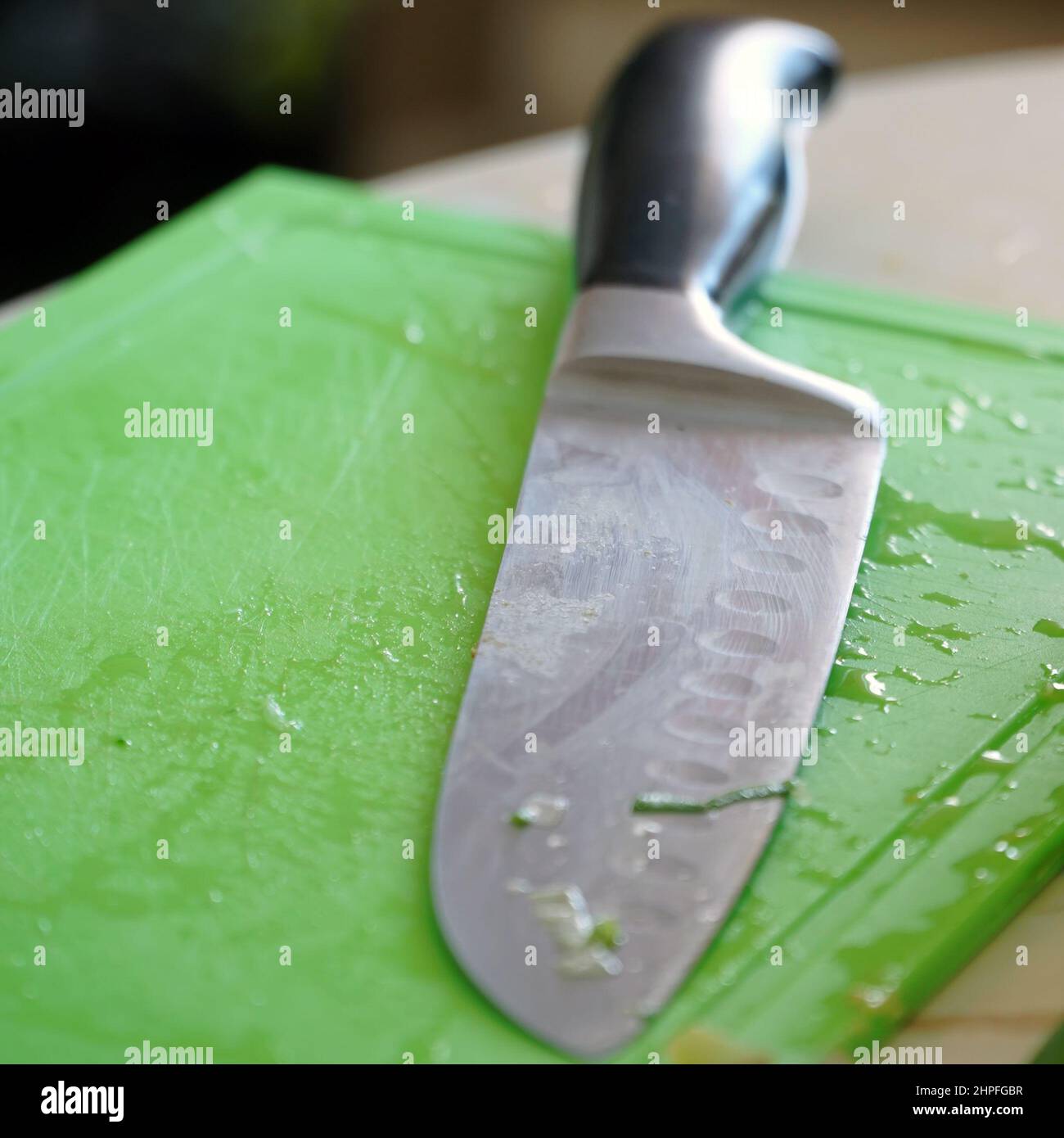 Couteau de cuisine sur une planche à découper en plastique vert Banque D'Images