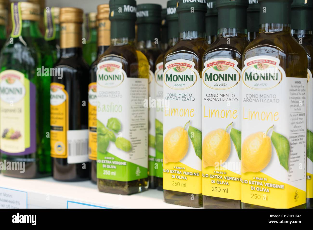 Lviv, Ukraine - 20 février 2022 : gamme de bouteilles à l'authentique marque italienne d'huile d'olive extra vierge Monini au supermarché, huile d'olive aromatisée Banque D'Images