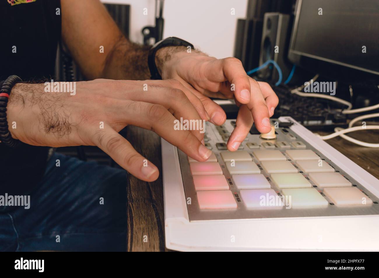 gros plan de mains caucasiennes faisant un battement, en utilisant un contrôleur midi dans un studio à la maison Banque D'Images