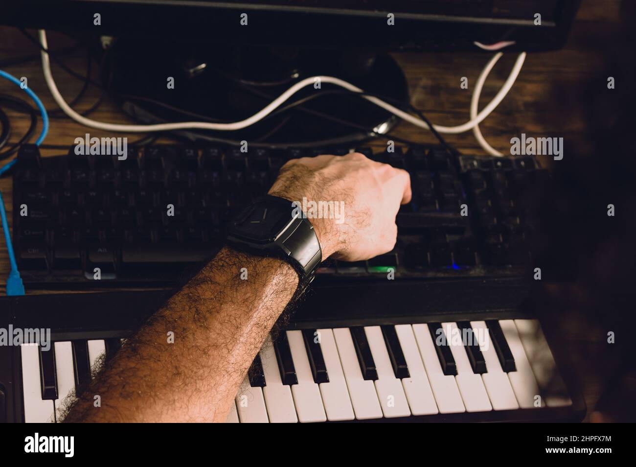 homme caucasien utilisant un clavier d'ordinateur produisant de la musique et la composition dans son studio à la maison, concept de production de musique. Banque D'Images