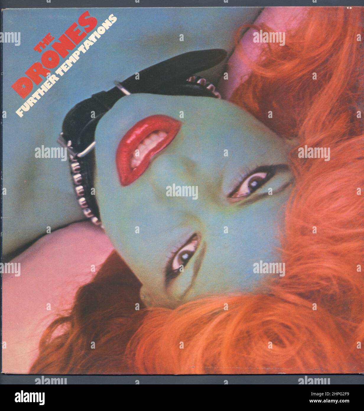 Les drones sont un groupe qui m'a passé même si je vivais à Manchester à l'époque, ils - comme quelques autres - ont piqué de la roche lourde pour punk. Mais j'ai admiré leur pochette d'album avec ce que l'on appelle souvent "la fille bleue", et j'ai surnommé un exemplaire d'un mur exposé dans l'un des magasins de disques locaux. Les détails sont difficiles à obtenir ; les photos avant et arrière étaient de Peter Higgins dont les contributions à enregistrer des couvertures étaient assez limitées, tandis que la conception de la couverture était de Ross J. Waters, son seul manchon punk parmi une sélection de versions de MOR, beaucoup pour la musique pour le plaisir. Banque D'Images