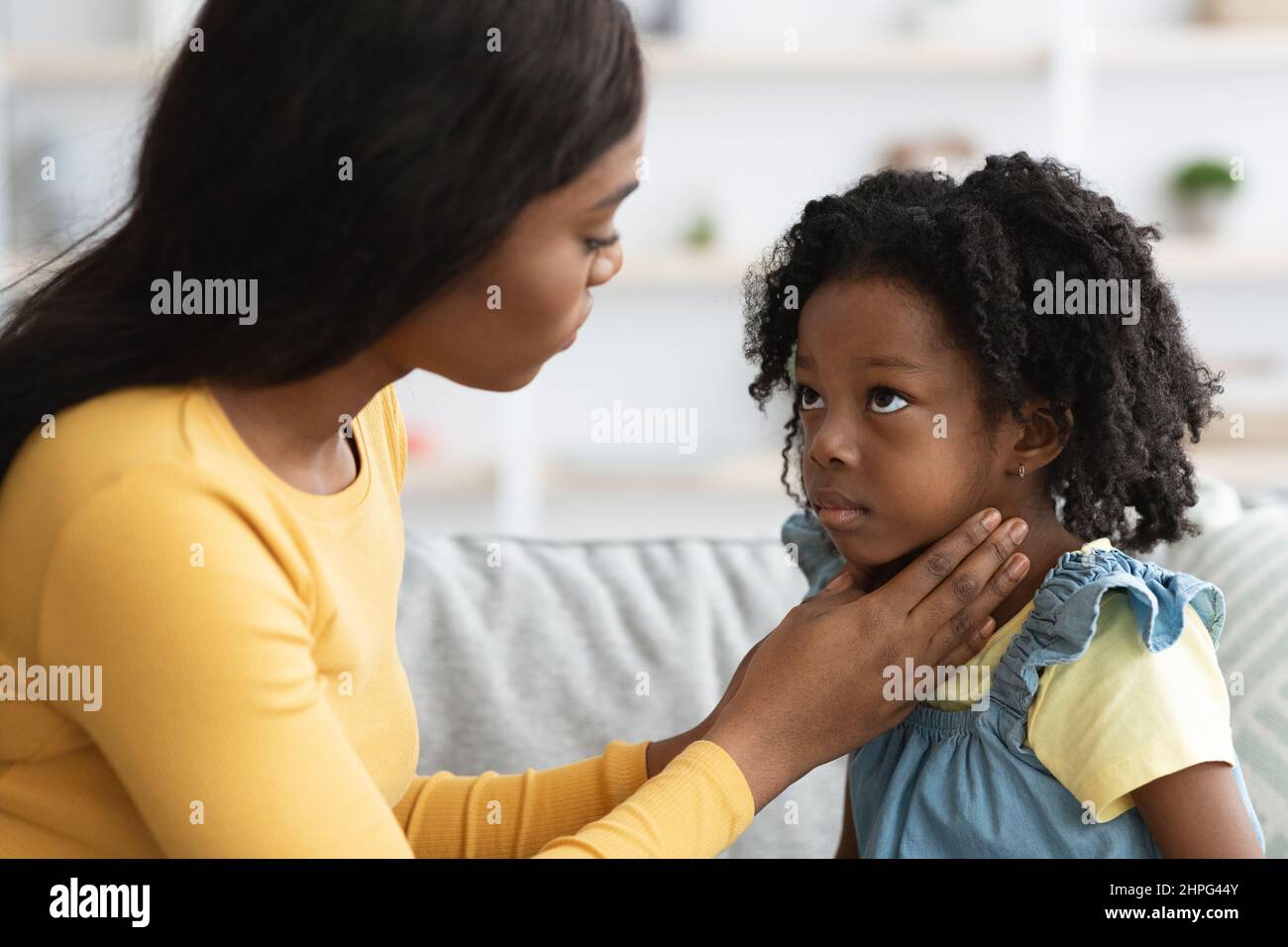 Mère noire prenant soin de son enfant malade souffrant de mal de gorge Banque D'Images