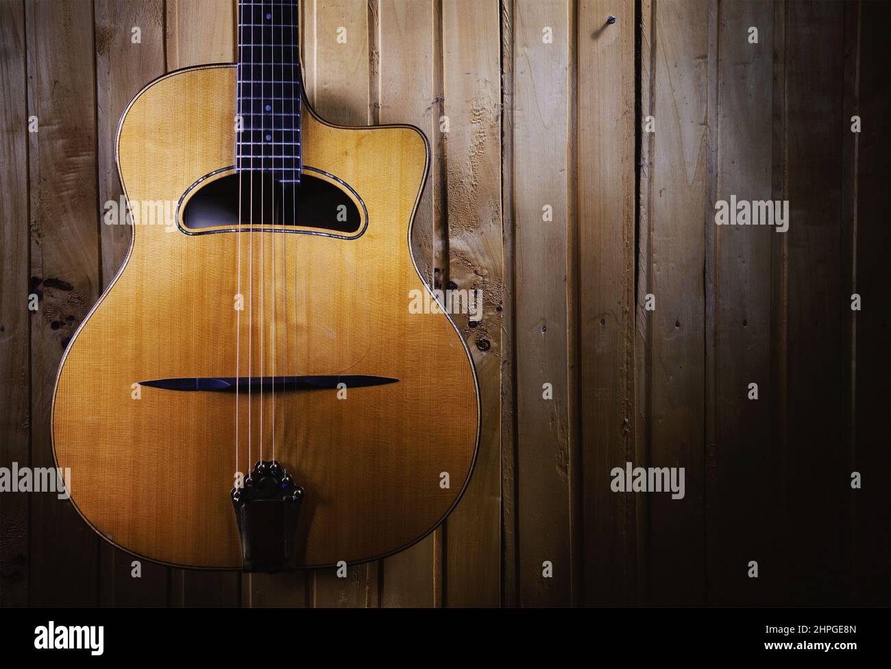 Des détails de guitare acoustique gitane jazz, pendus sur un mur en bois. Banque D'Images