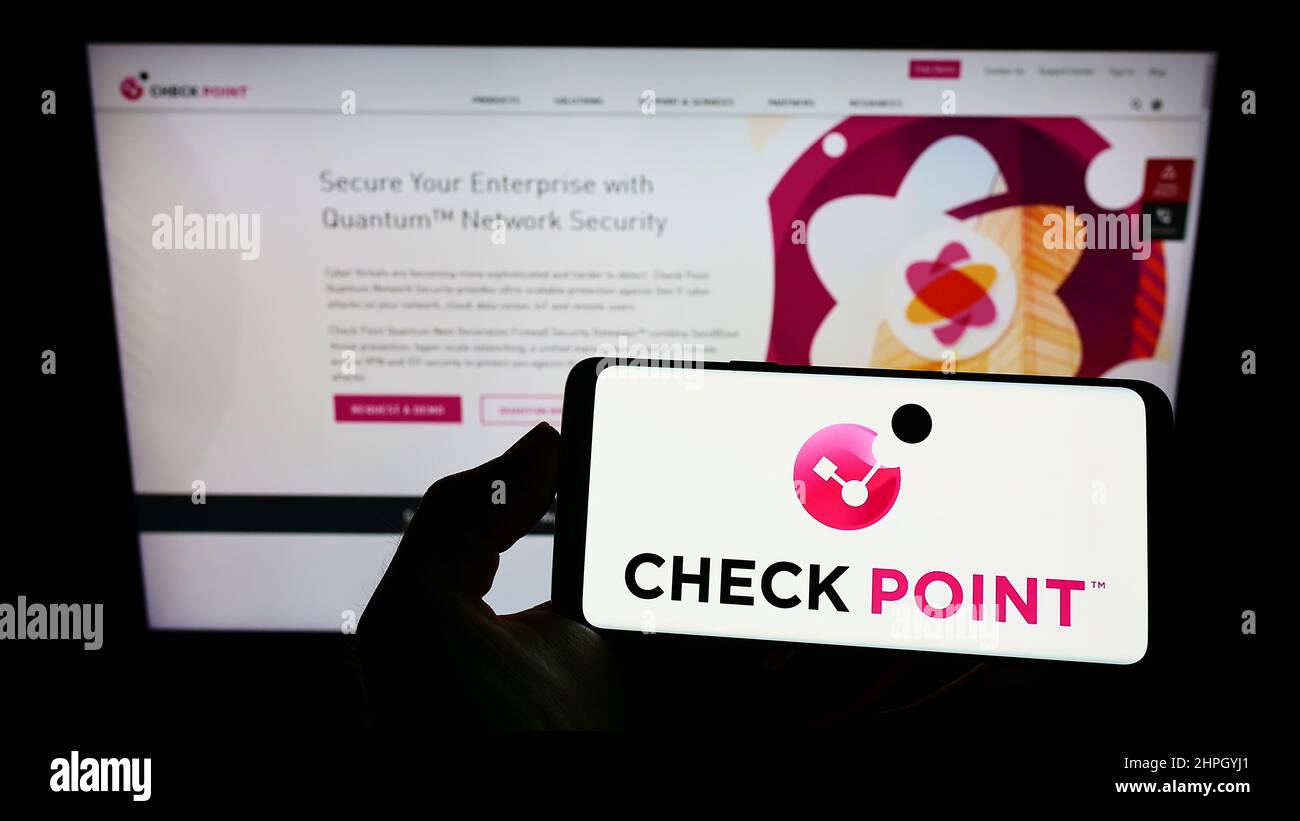 Personne détenant un smartphone avec le logo de la société Check point Software technologies Ltd. À l'écran devant le site Web. Mise au point sur l'affichage du téléphone. Banque D'Images