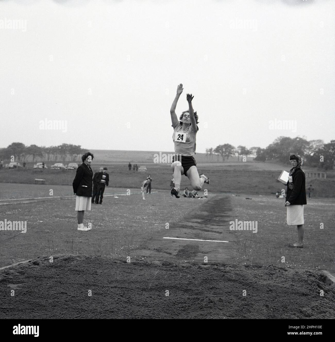 1960s, historique, une athlète féminine adulte en plein air faisant le long saut, Fife, Écosse, Royaume-Uni. La vitesse, la force et l'agilité - et la détermination - sont toutes nécessaires dans ce grand événement sur piste et sur le terrain, où l'objectif est de sauter le plus loin possible dans un bac à sable à partir d'un point de décollage sur le run-up. Un événement pour hommes dans les Jeux Olympiques modernes de 1896, les femmes ont pris part pour la première fois au long saut olympique en 1948 à Londres. Banque D'Images