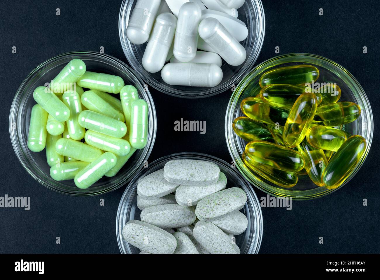 Suppléments pour le sport sain dans des pilules et des capsules comme les vitamines et l'huile de foie de morue sur fond sombre Banque D'Images