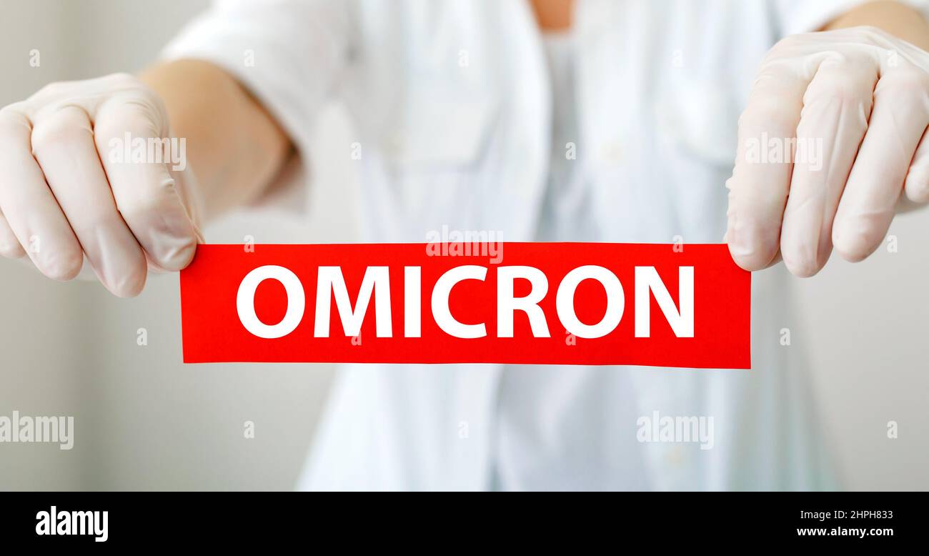OMICRON signe d'avertissement rouge avec texte nouveau Omicron variante Covid 19 dans les mains du médecin en manteau blanc et gants.Longue bannière Web Banque D'Images