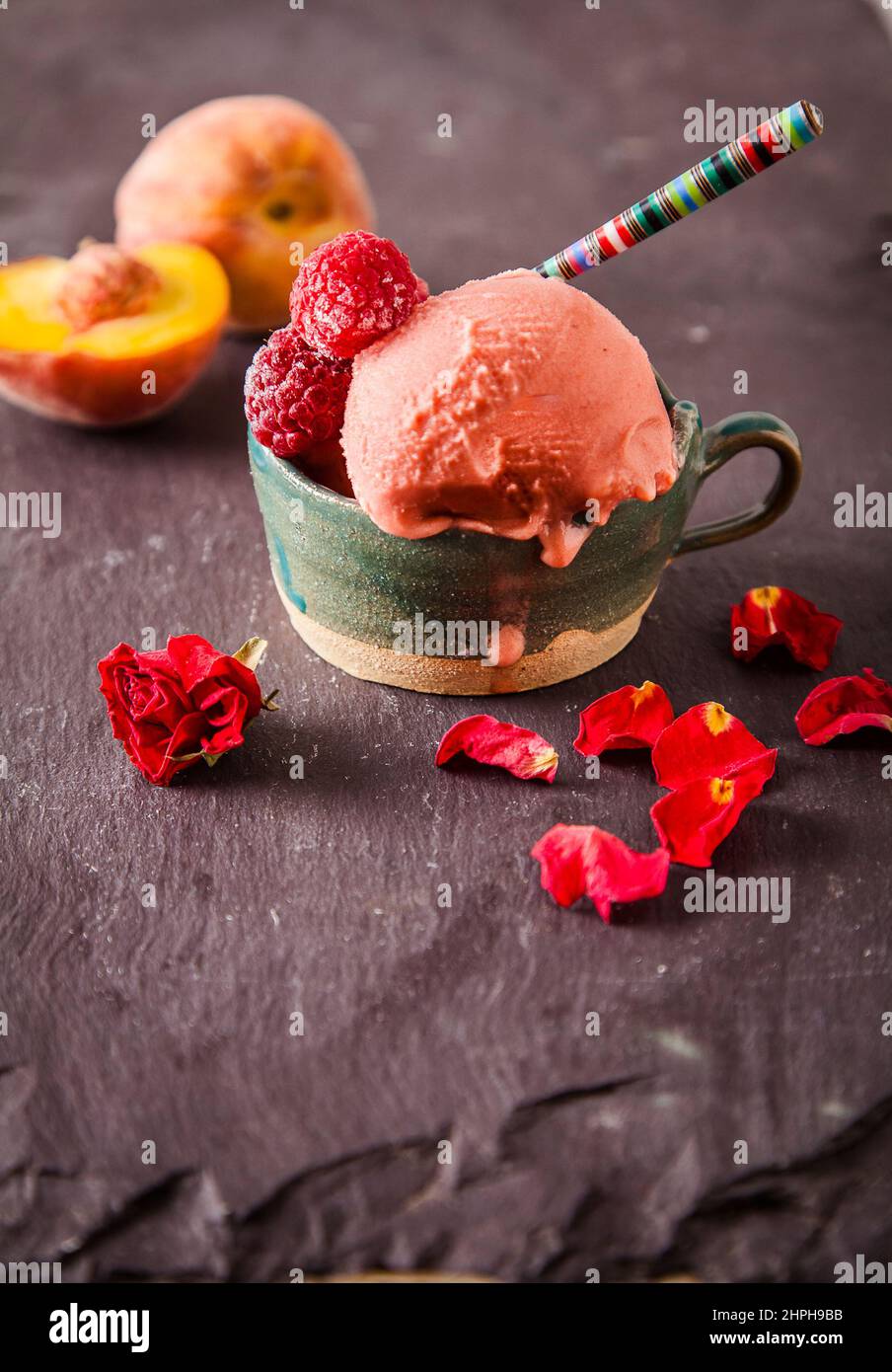 Glace de style italien (glace) dans une tasse avec des fruits sur fond d'ardoise. Concept de menu sucré et d'été. Banque D'Images